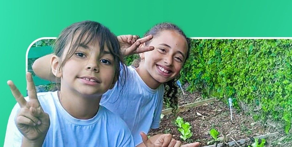 Alunas da Escola Recanto em atividade ao ar livre junto à horta.